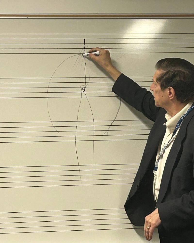Instructor drawing a diagram of a piano hammer on a whiteboard during a technicians' seminar